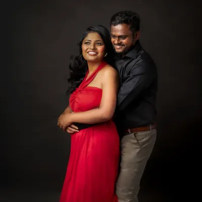 Together is a wonderful place to be. This couple's portrait captures a moment of laughter and affection, with the vibrant red dress adding a touch of romance and passion.