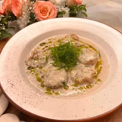 A close-up of my Green Chili Malai Prawns. I braise succulent Andaman prawns in a rich butter cream sauce infused with green chili, then finish it with scallions and chili oil for a dish that is both creamy and spicy.