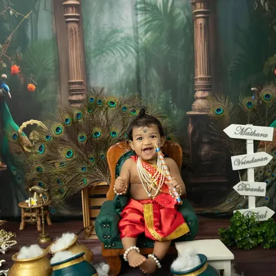 A joyful little Krishna sitting on his throne. Our Janmashtami mini sessions are filled with vibrant colors, peacock feathers, and playful props like pots of "butter".