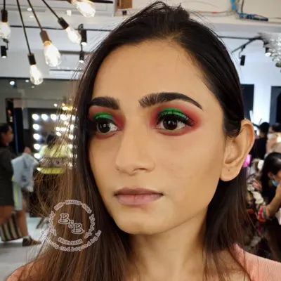 A close-up of a dramatic halo eye makeup look. I used a bold, shimmery green on the center of the eyelid and blended it into a warm, matte red to create a striking contrast. This technique really makes the eyes pop.