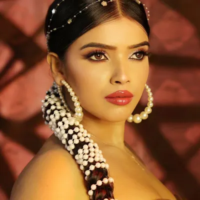 A stunning beauty close-up focusing on intricate hair styling with pearls and flawless makeup. This type of shot is perfect for showcasing the skills of both the photographer and the hair and makeup team.