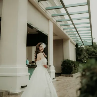 A beautiful glance over the shoulder. This portrait captures the bride in her stunning white gown, her happy expression and the elegant setting creating a timeless and graceful image.