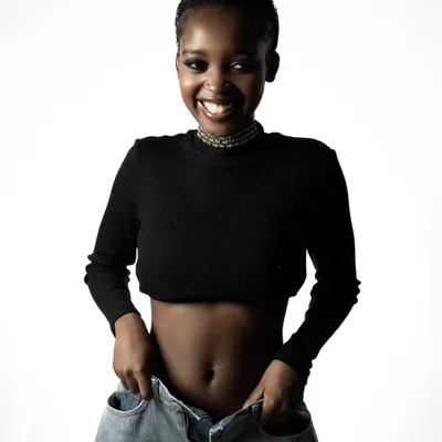 A bright and joyful portrait against a clean white background. The model's natural smile and the simple styling create a fresh and approachable look.