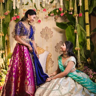 For our bride Sindhu's pellikuthuru ceremony, we designed a backdrop inspired by the grace of a peacock. The rich colors of her lehenga were complemented by a traditional setting fatores of floral garlands and banana leaves.