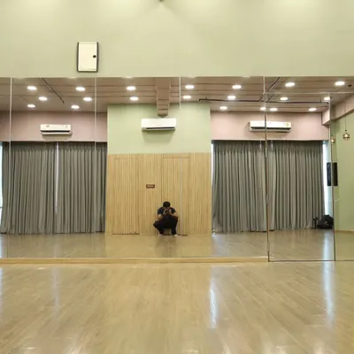 Our versatile studio space is available for rent. This wide shot shows the full expanse of the floor, perfect for large group rehearsals.