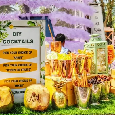 The complete setup for my DIY Cocktails station. A clear sign guides guests to pick their spirit, spice or fruit, and mixer, while engraved coconuts and stylish copperware add a premium touch to this interactive gin bar.