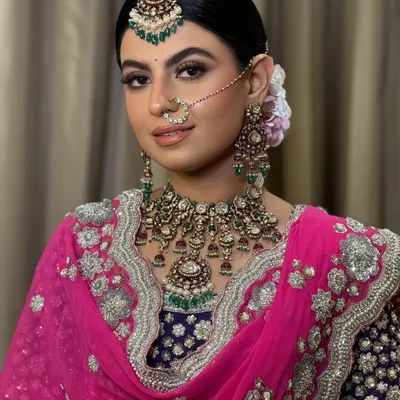 A stunning Sikh bride ready for her Anand Karaj. I created a sleek, low bun adorned with fresh flowers to securely hold her dupatta while complementing her intricate jewellery, including the maang tikka and passa.