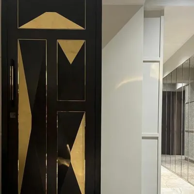 The entrance to this Juhu apartment features a custom-designed door with striking geometric brass inlays. This bespoke detail serves as a piece of art and sets a luxurious tone from the very first step inside.