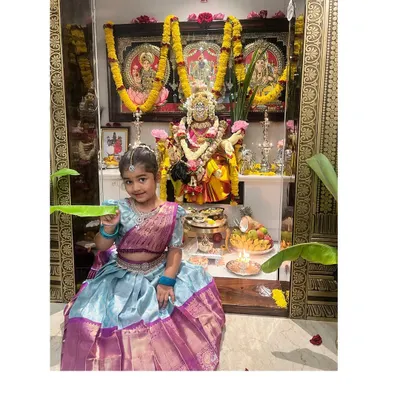 A little client dressed in a custom langa blouse for Varamahalakshmi pooja. The skirt is sky blue with a rich purple border.