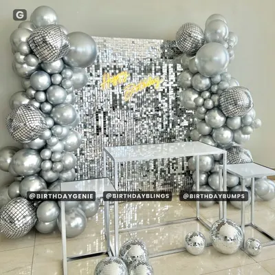 A dazzling disco-themed setup featuring a silver shimmer wall and a matching all-silver balloon arch. The disco ball accents and neon "Happy Birthday" sign complete this groovy party look.