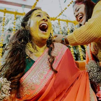 This is the pure, uninhibited joy of a haldi ceremony. We live for capturing these moments of explosive laughter and celebration as the bride is covered in turmeric by her loved ones.