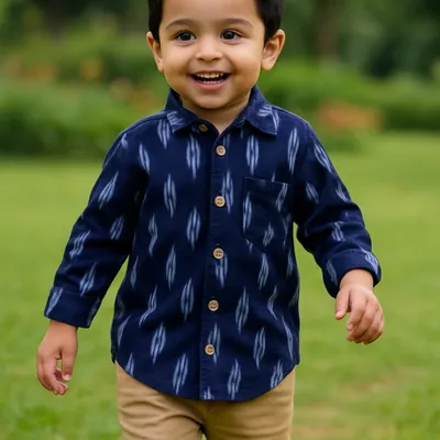 This is one of my absolute favorite shots. A happy boy running freely in our classic navy blue Ikat shirt. It’s made from handwoven cotton, making it incredibly soft and breathable for all-day adventures.