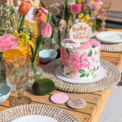 I love seeing my cakes as part of a beautiful celebration. This "Baby in Bloom" floral cake was the star of a gorgeous baby shower, and this photo captures the joy of the moment perfectly. The bright pink flowers on the cake matched the fresh tulips on the table.