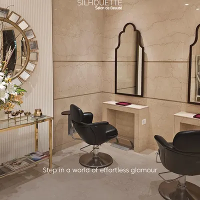Step into a world of effortless glamour. This corner of our salon, featuring plush black leather chairs and elegant decor, is designed to provide a sophisticated and comfortable grooming experience.