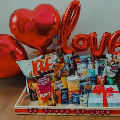 Celebrating a decade of love with this extravagant 10th-anniversary hamper. It's overflowing with snacks, chocolates, a special gift box, and large 'LOVE' balloons, all personalized with photos from the past ten years.