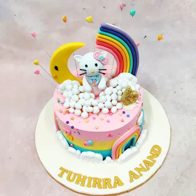 This Hello Kitty rainbow cake is a sweet daydream brought to life. The iconic character sits atop fluffy clouds, surrounded by a crescent moon and a vibrant rainbow, making it a perfect centerpiece for a magical and colorful birthday party.
