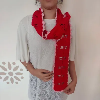 This is the Aerith Scarf, a beautiful and delicate piece featuring a filet crochet dragonfly pattern and a lovely ruffled edge.