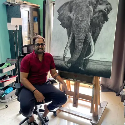 In my studio, seated next to the completed 40 by 50 inch 'Gajraaj' elephant portrait. This shows the final piece on the easel where it was created.