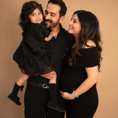 A classic portrait of a family of three, soon to be four. The way they look at each other, full of love and excitement, is what makes this maternity photo so special.