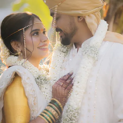 A classic Maharashtrian wedding moment, filled with golden hour light. The way Srushti looks at Chinmay is a perfect example of the candid, emotional connection we aim to capture.