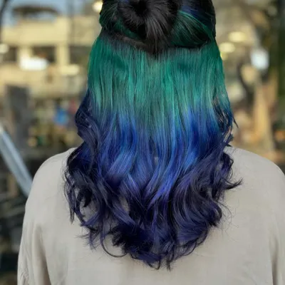Our hero look. This peekaboo style features a stunning gradient of green to blue, hidden under a layer of dark hair. It's the perfect way to experiment with bold color in a subtle, yet impactful way.