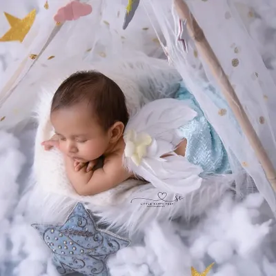 An angel sleeping on a bed of clouds. With delicate wings and a starry backdrop, this setup is perfect for capturing the heavenly innocence of your newborn.