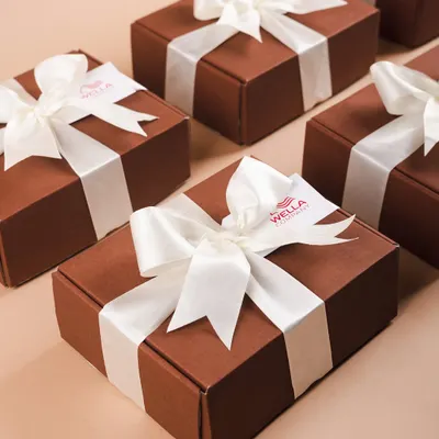 Minimalist and elegant corporate hampers for Wella. These simple brown boxes with a crisp white satin ribbon prove that sometimes, less is more.