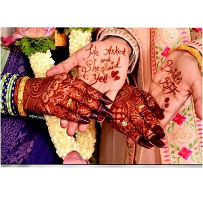 A fun and personal touch for an engagement ceremony. The groom's hand reads "He Asked and She Said Yes," while the bride's best friend has "Bride's BFF" written on her palm.
