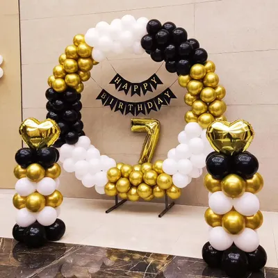 A chic and modern birthday setup using a circular balloon arch in black, white, and gold. This clean design is perfect for any age and includes a 'Happy Birthday' banner and a large foil number.