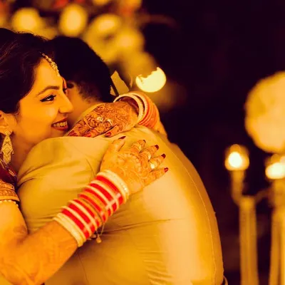 A warm, heartfelt hug during the reception. The candlelight creates a romantic atmosphere, and the bride's smile shows a moment of pure happiness and comfort. This is the kind of unscripted emotion I strive to capture.