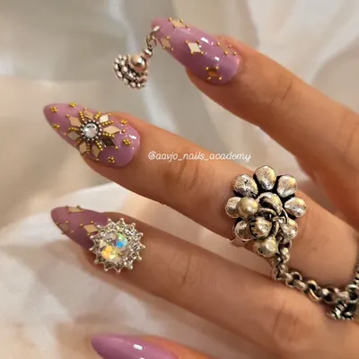 A stunning Navratri look. This set features a beautiful purple base with gold foil flakes, intricate star charms, and a dangling 'jhumka' charm for a truly festive and traditional feel.
