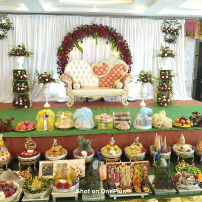 A full and elaborate Seer Thattu display for a traditional ceremony. This arrangement includes a wide variety of decorated platters, from fruits and sweets to beautifully wrapped gifts.