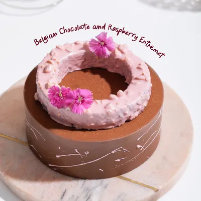 Our Belgian Chocolate and Raspberry Entremet, a stunning creation with layers of rich mousse, crunch, and confit, all dressed in edible elegance.