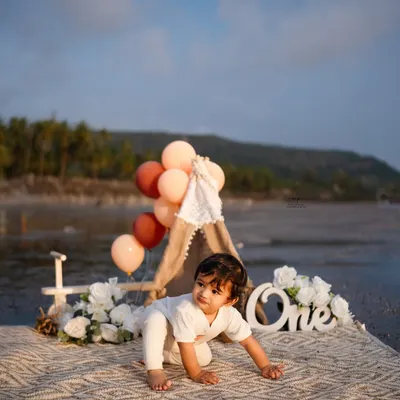 A little explorer crawling on the beach during his first birthday photoshoot. The natural setting and soft light create a beautiful, candid moment.