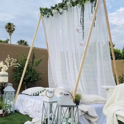 This elegant A-frame tent is perfect for a sophisticated outdoor brunch or sundowner. Dressed in sheer white fabric and florals, it provides a comfortable and stylish retreat for any celebration.