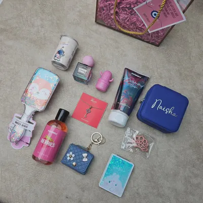 Here is a flat-lay view of the items in my 'Cute Hamper for a Sister'. It shows the personalized jewelry box, astronaut-themed mug, body lotion, perfume, hairbrush, and other fun trinkets included in the gift.
