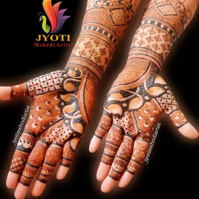 A stunning example of full-coverage bridal mehndi. This design uses negative space and bold lines to create a striking pattern that extends up the arm.