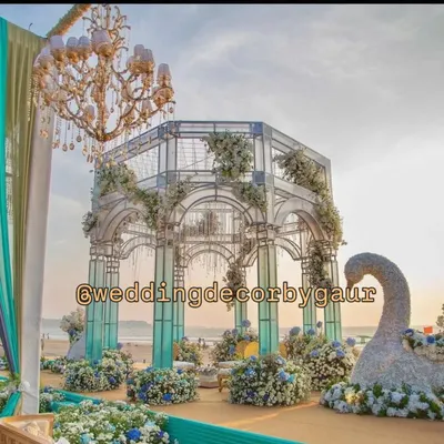 A breathtaking seaside mandap we constructed for a beach wedding in Goa. This custom-built glasshouse structure, adorned with blue and white hydrangeas, created a magical setting against the ocean backdrop.