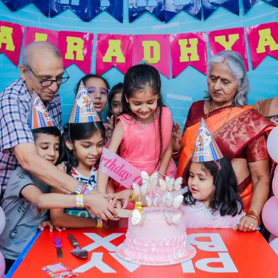 Grandparents joining in on the cake-cutting tradition. Our parties are designed for the whole family to enjoy and create lasting memories together.