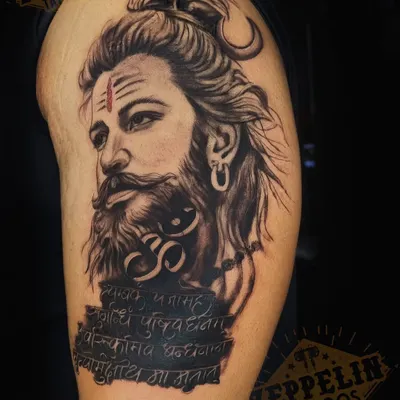 A portrait of Lord Shiva for a client's upper arm. I focused on creating a realistic yet powerful expression, combining it with the Om symbol and the Maha Mrityunjaya mantra for a deeply spiritual piece.