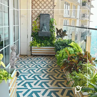 A zen corner created on a balcony, featuring a Buddha water fountain nestled among lush greenery. This design combines geometric floor tiles with custom planters to create a modern yet peaceful retreat.