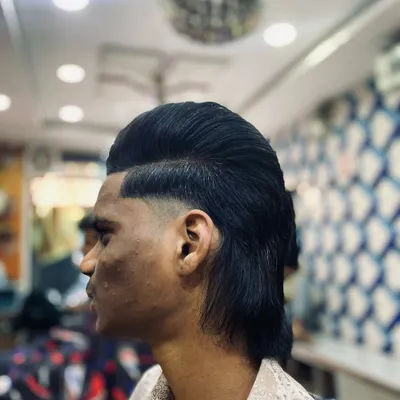 The modern mullet is one of my specialties. I keep it fresh with a seamless fade on the sides, a styled pompadour on top, and a clean, flowing look at the back.