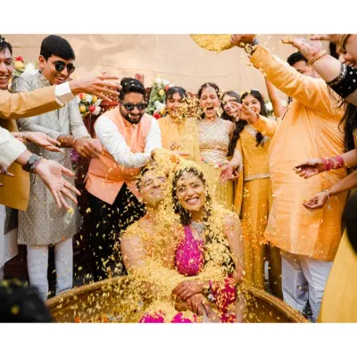 A perfect storm of joy! The couple is showered with flower petals by their loved ones in a moment of pure, chaotic happiness. This is what a fun-filled Haldi ceremony looks like.