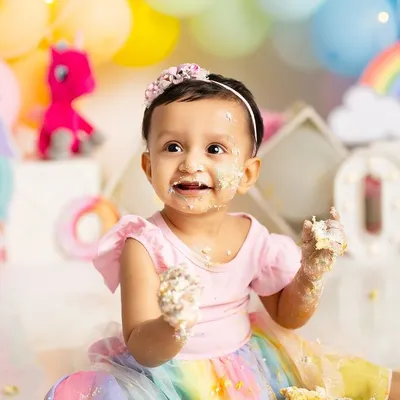 The pure joy of discovering cake for the first time! This little one's messy hands and face during her rainbow-themed cake smash session is exactly the kind of happy, authentic moment I love to capture.