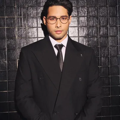 A close-up of Siddhant Chaturvedi in a custom double-breasted suit by Zafir and Shadab. The sharp tailoring, crisp white shirt, and classic tie create a powerful and sophisticated look.