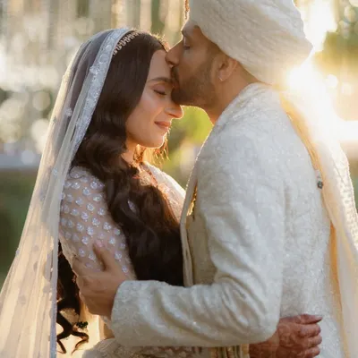 A timeless portrait captured in the golden hour light at Gallops, Mumbai. The groom's gentle kiss and the bride's serene smile create a moment of pure, heartfelt emotion on their wedding day.