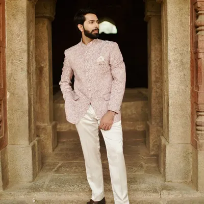This Jodhpuri suit is a perfect blend of men's fashion and traditional Indian wear, ideal for a summer wedding. The light pink, subtly printed fabric and classic cut ensure you stay stylish and cool, embodying the essence of royal menswear.