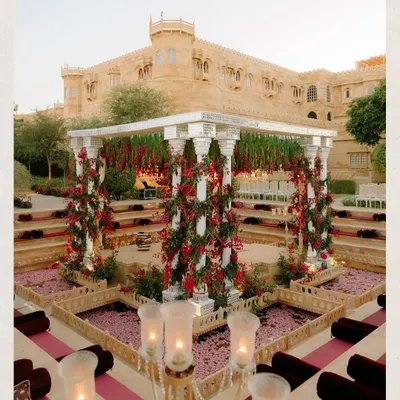 The full view of the ceremony space we designed at Suryagarh, Jaisalmer. The monochromatic red bougainvillea against the majestic sandstone backdrop created a timeless and dramatic setting for Kahran and Gourav's vows.