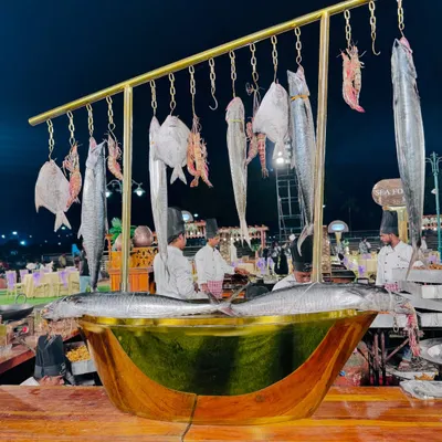 My signature seafood display, featuring a variety of fresh fish like pomfret and surmai, and prawns hanging over a large brass vessel.
