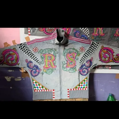 This is the front view of a custom hoodie I designed, featuring the initials 'R' and 'S' in a highly decorative, multi-colored style. The design incorporates flourishes, checkered patterns, and geometric details for a bold, personalized statement.